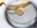 Close-up of the watch's textured crown, clearly showing the embossed Michel Herbelin brand logo.