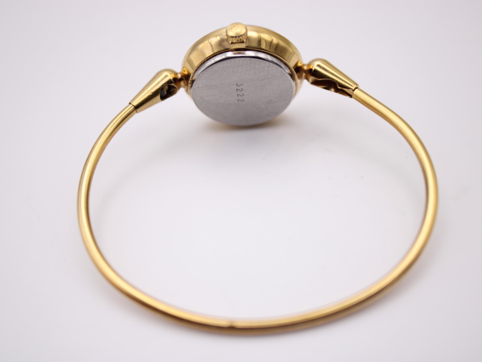 Rear view of the gold tone Michel Herbelin watch, showcasing the full integrated bangle bracelet and the case back.