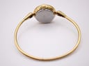 Rear view of the gold tone Michel Herbelin watch, showcasing the full integrated bangle bracelet and the case back.