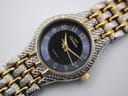 Close-up of the Manin Cartear black dial, gold Arabic numerals, and textured two-tone bracelet.