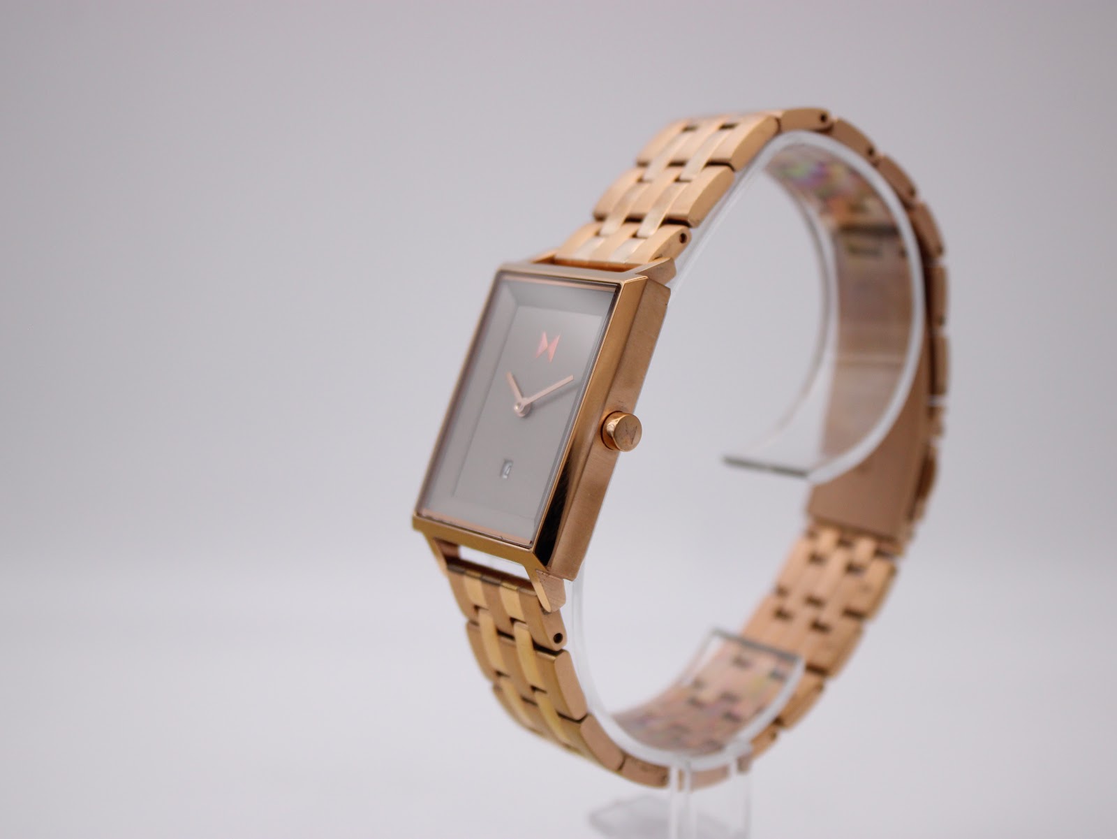 Angled side view of MVMT Signature Square watch showing the rose gold tone case and integrated steel bracelet.