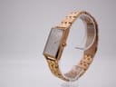 Angled side view of MVMT Signature Square watch showing the rose gold tone case and integrated steel bracelet.
