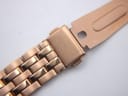 Close-up of the rose gold tone steel deployment clasp, engraved with 'MVMTK'.