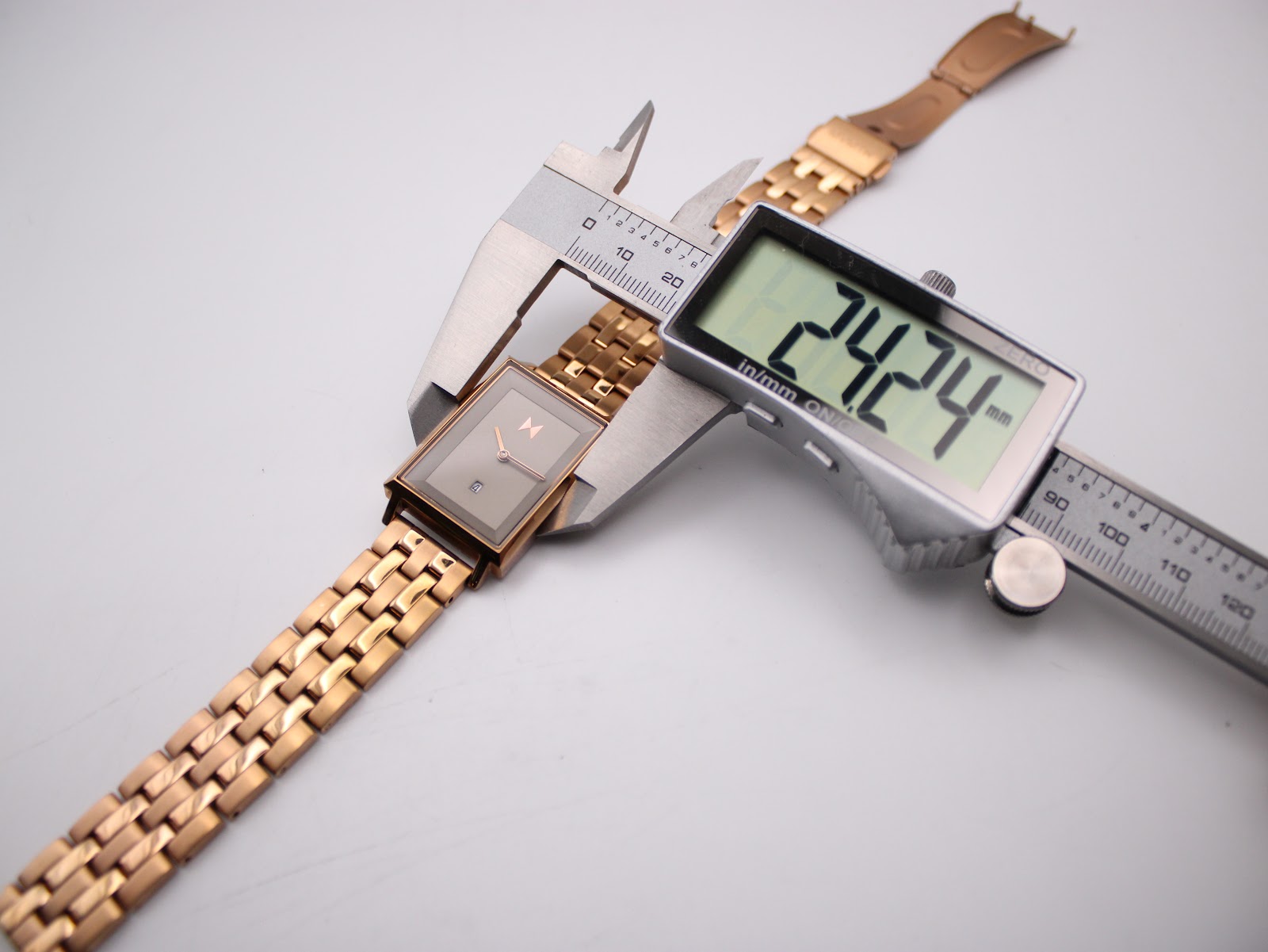 Overhead view of the MVMT Signature Square watch with a digital caliper measuring the case width at 24.24mm.
