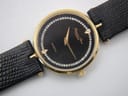 Detailed close-up of the black dial with gold hands, diamante hour markers, and brand/model text.
