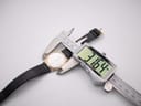Digital caliper measuring the watch case diameter, showing 31.64mm on the display.