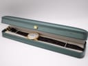 The Jean Perret QJ watch laid inside a generic dark green watch box.