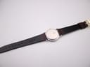 Underside view of the watch and strap, showing the case back details and 'Lizard Calf 16' marking on the strap reverse.