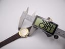 Digital caliper measuring the watch case diameter, displaying 29.84mm.