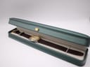 The Gucci watch presented inside a generic green display box with a cream interior.