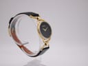 Opposite side profile view of the Gucci watch on a stand, highlighting the unique gold-tone link system.