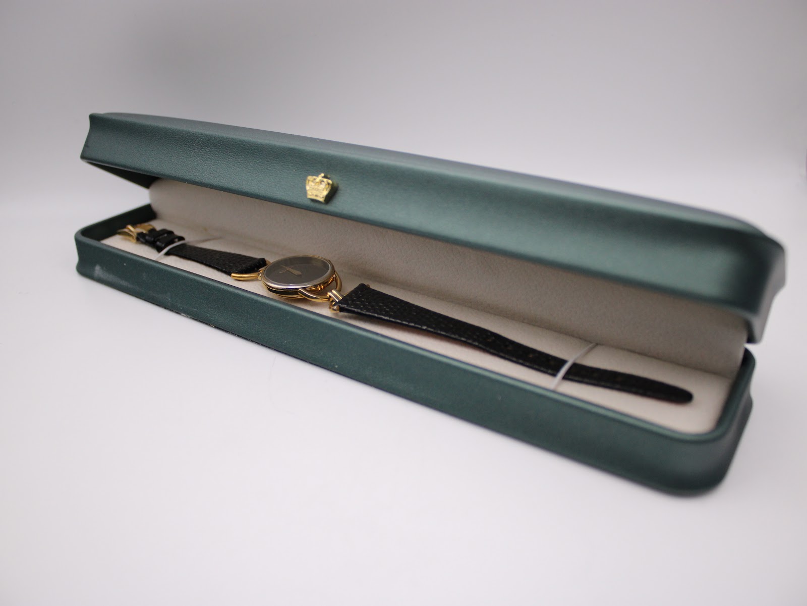 The Gucci watch displayed inside a green presentation box with a cream interior.