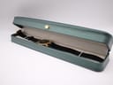 The Gucci 3400M watch lying inside a generic green presentation box, illustrating its proportions.