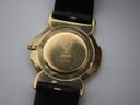 Close-up of the gold-plated case back of the Gucci 3400M, showing the Gucci crest, model number 3400M, and serial number 9371123, with visible surface scratches.