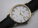 Detailed close-up of the white dial with black Roman numerals, gold-tone hands, and date window.