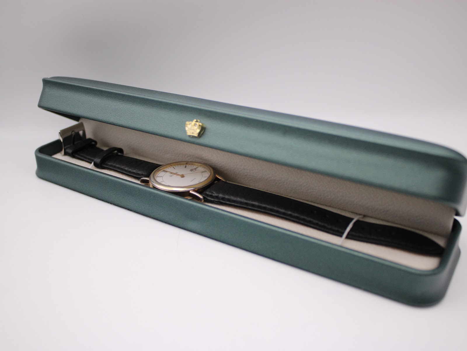 Bulova watch and strap resting inside a plain green watch presentation box (box not included).
