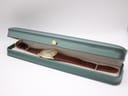 Roamer Searock watch laid inside a long, dark green presentation box.