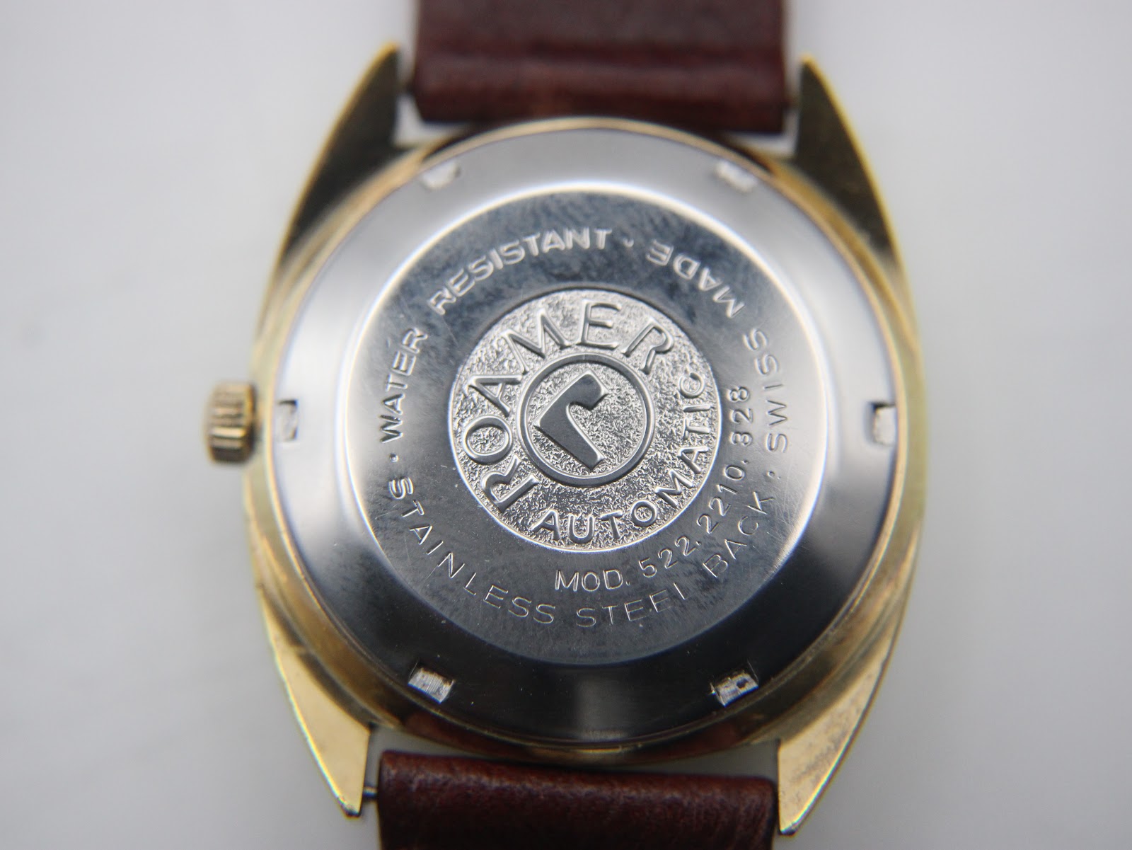 Close-up of the stainless steel screw-down case back, showing "Roamer automatic", "water resistant", "Swiss made".