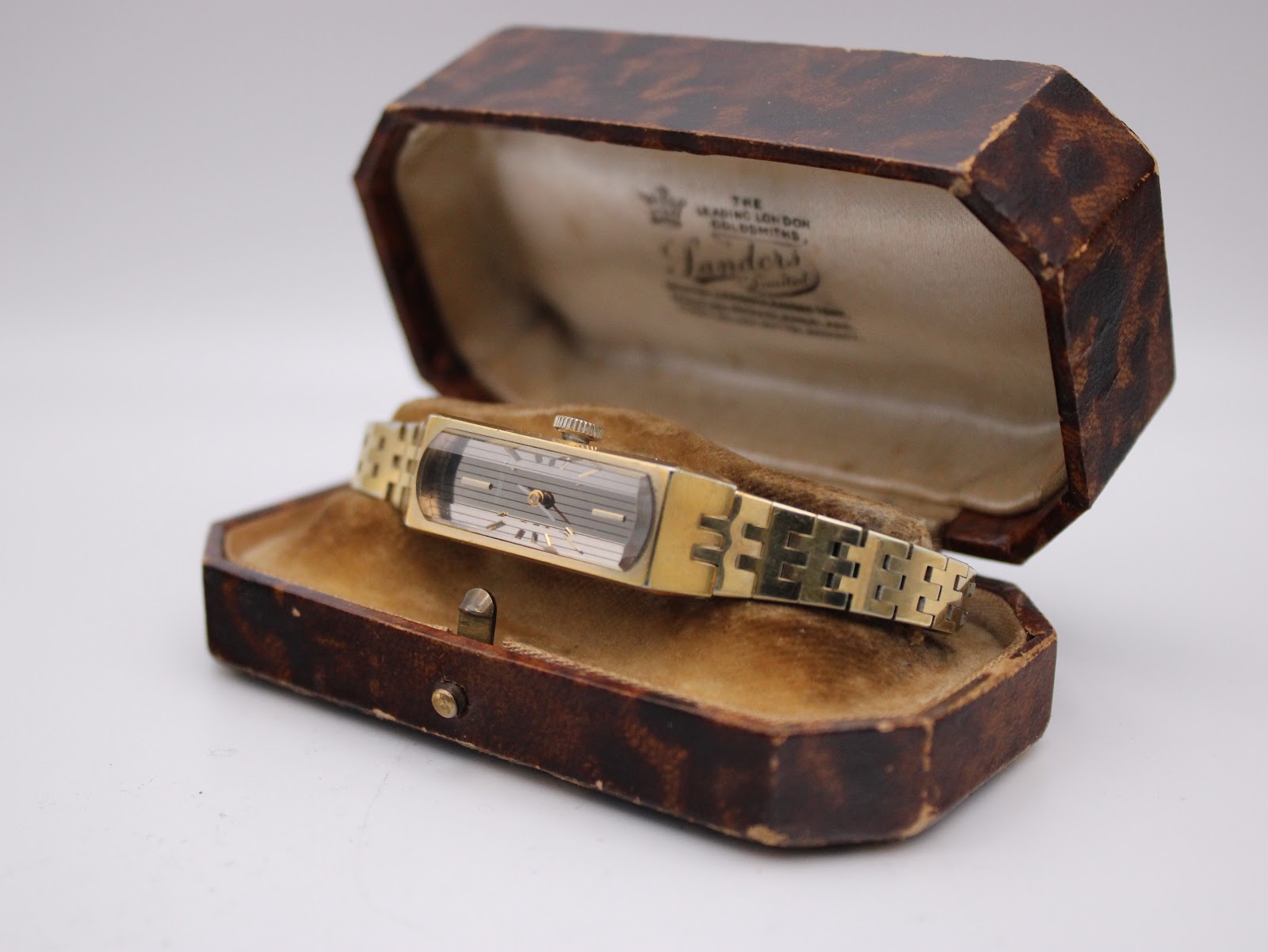 Angled view of the vintage Seiko 1520 watch sitting in an open, ornate vintage presentation box, showing the gold bracelet. (Note: this box is not included with the watch.)