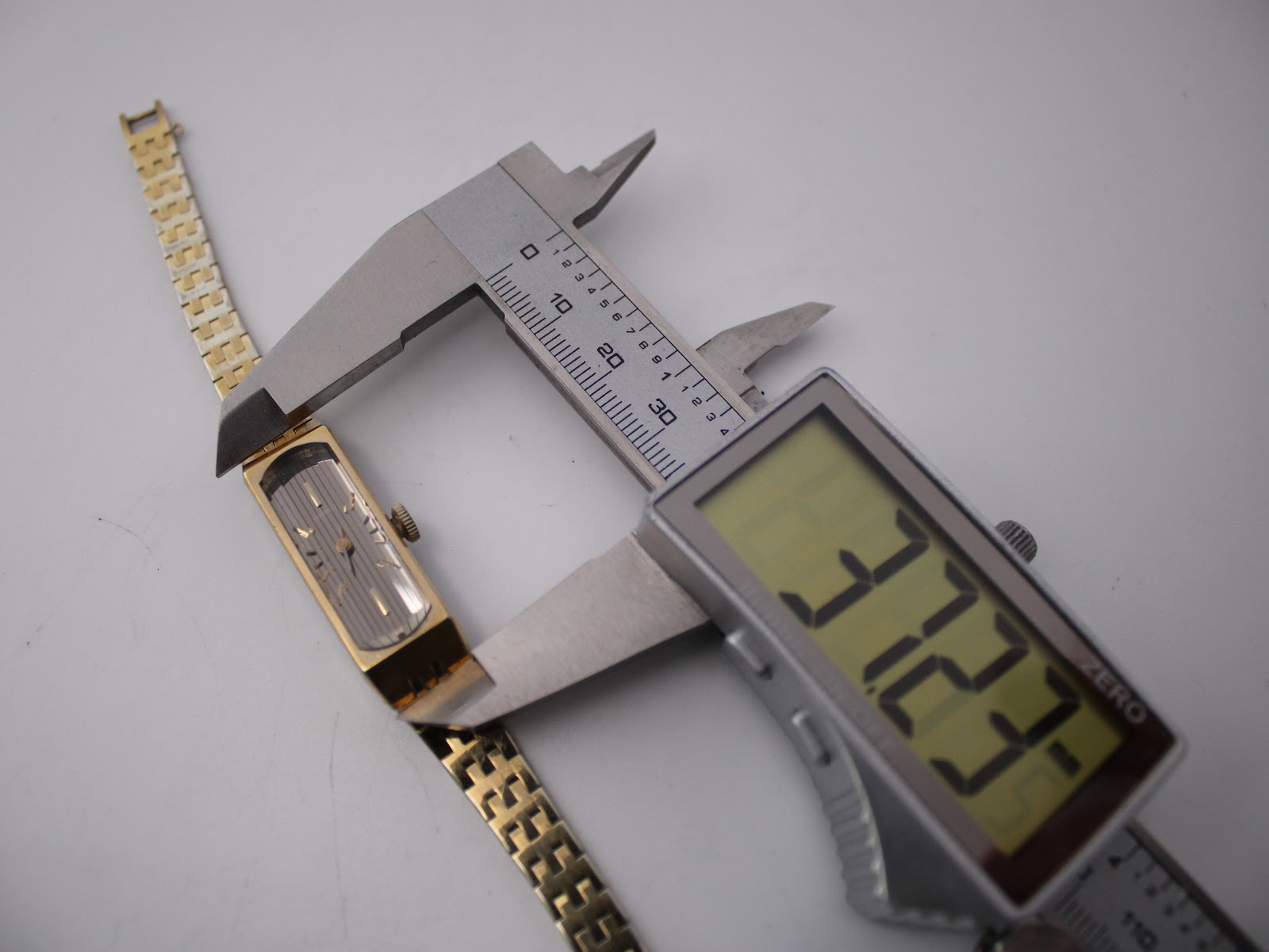 Digital caliper measuring the length of the Seiko watch case, displaying 31.23mm.