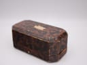 The closed vintage presentation box with a tortoise-shell pattern. (Note: this box is not included with the watch.)