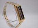 Opposite side view of the gold-plated Seiko watch on a clear stand, showing the case profile.