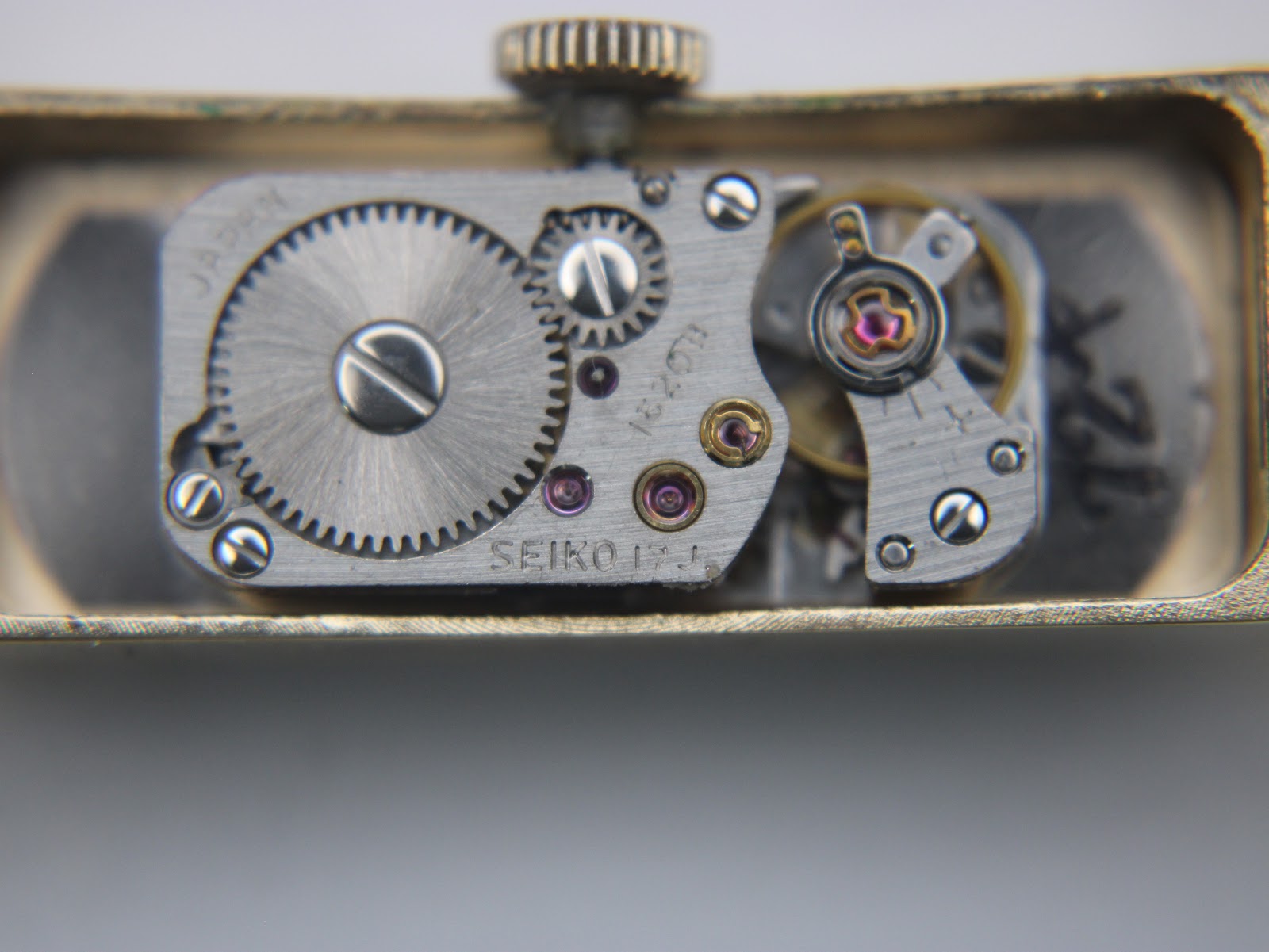 Close-up of the manual wind movement, showing gears, jewels, and 'SEIKO 1520 17J' engraving.