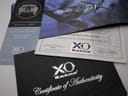 Stack of XO RETRO papers and brochures, including the Certificate of Authenticity and material referencing a 1953 Rolls Royce Silver Wraith.