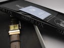 The XO RETRO watch resting in its original black presentation box, with accompanying papers visible.