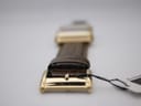Close-up of the gold-tone pin buckle on the brown leather strap, showing its polished finish.