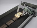 Digital caliper measuring the width of the XO RETRO watch case at 30.77mm, showing the watch inside its box.