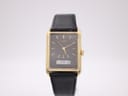 Front view of the Seiko E029-5540 watch, showing its gold rectangular case, black dial, gold baton indices, and ana-digi display.