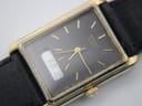 Detailed close-up of the black dial of the Seiko watch, showing the gold applied baton indices, gold hands, "SEIKO QUARTZ" text, and the digital display showing "FA 10". Some wear on the gold plating around the crystal is visible.