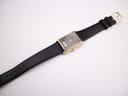 Overhead view of the entire Seiko watch laid flat, displaying the black leather strap with its gold-tone buckle, against a white background.