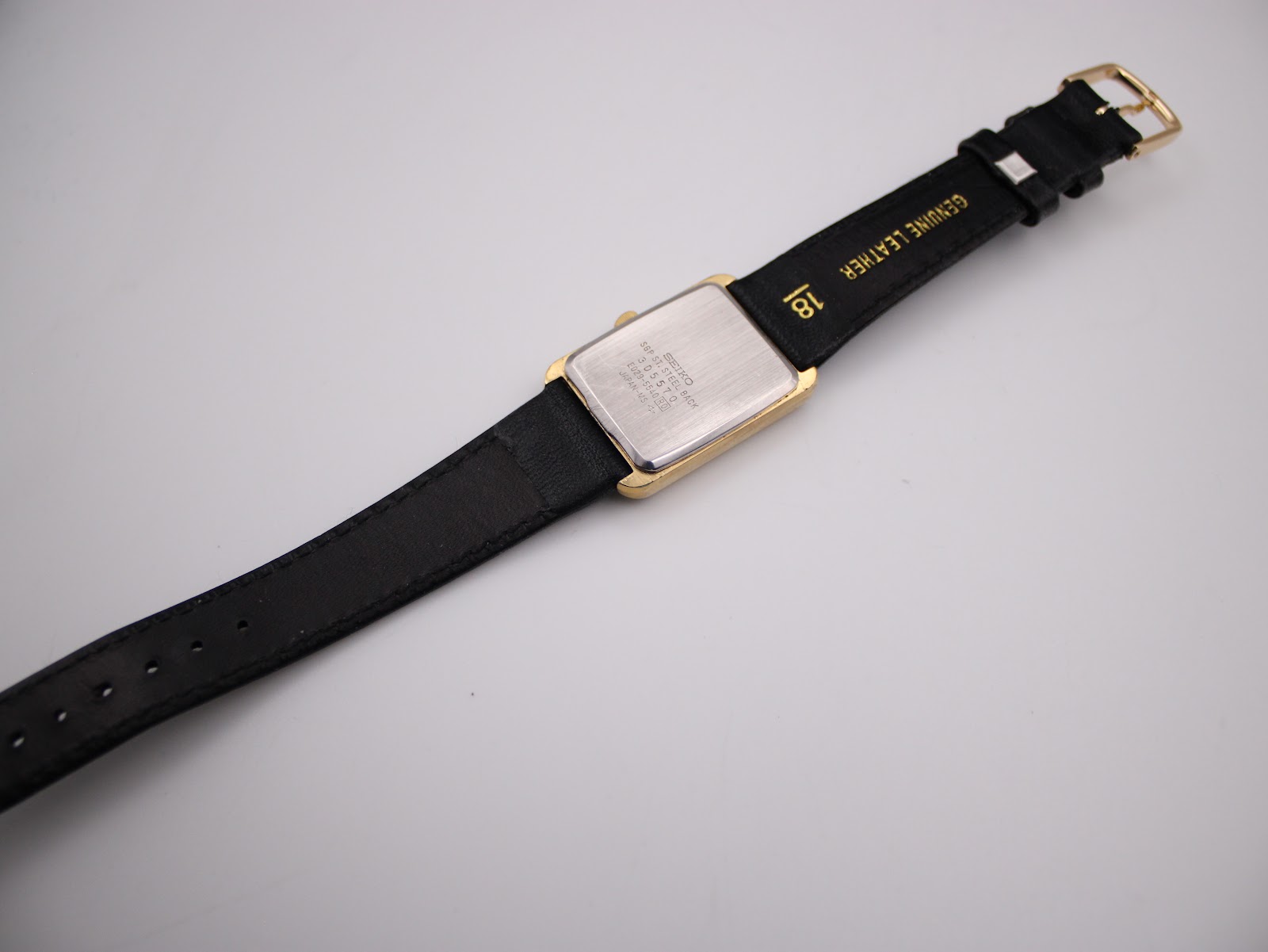 Rear view of the Seiko watch and strap, revealing the "GENUINE LEATHER 18" marking on the strap and the watch's case back.