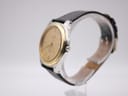 Angled side view of the Tissot PRX P380 watch showing the gold bezel and stainless steel case with the crown.