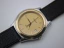 High-angle close-up of the Tissot PRX P380 gold dial with baton indices, date window at 3 o'clock, and the texture of the black leather strap.
