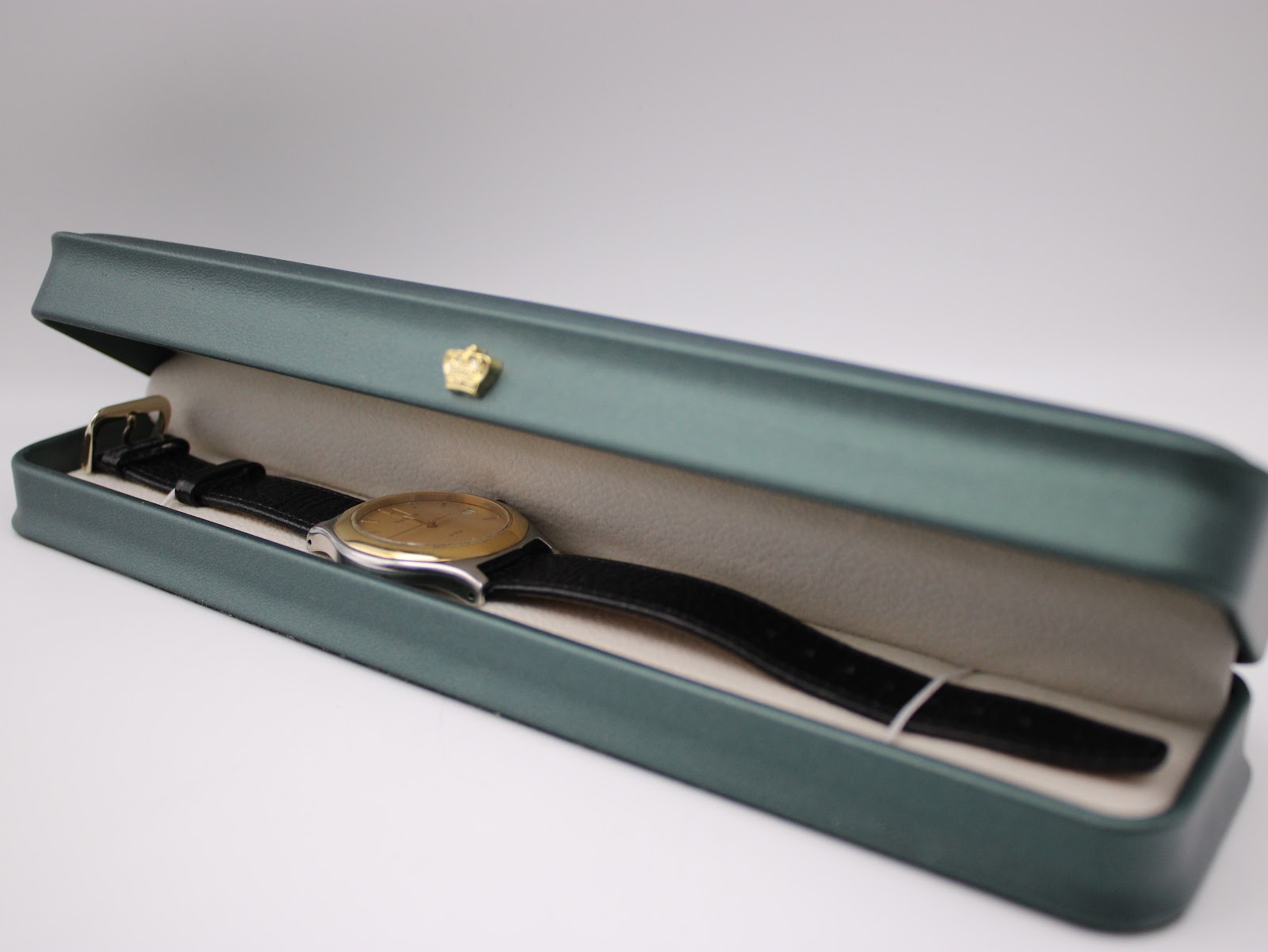 The Tissot PRX P380 watch with its black leather strap resting inside a dark green, non-original presentation box with a cream interior.