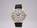 Front view of the Roamer Searock watch with gold tone case, white dial, black Arabic numerals, and black leather strap.