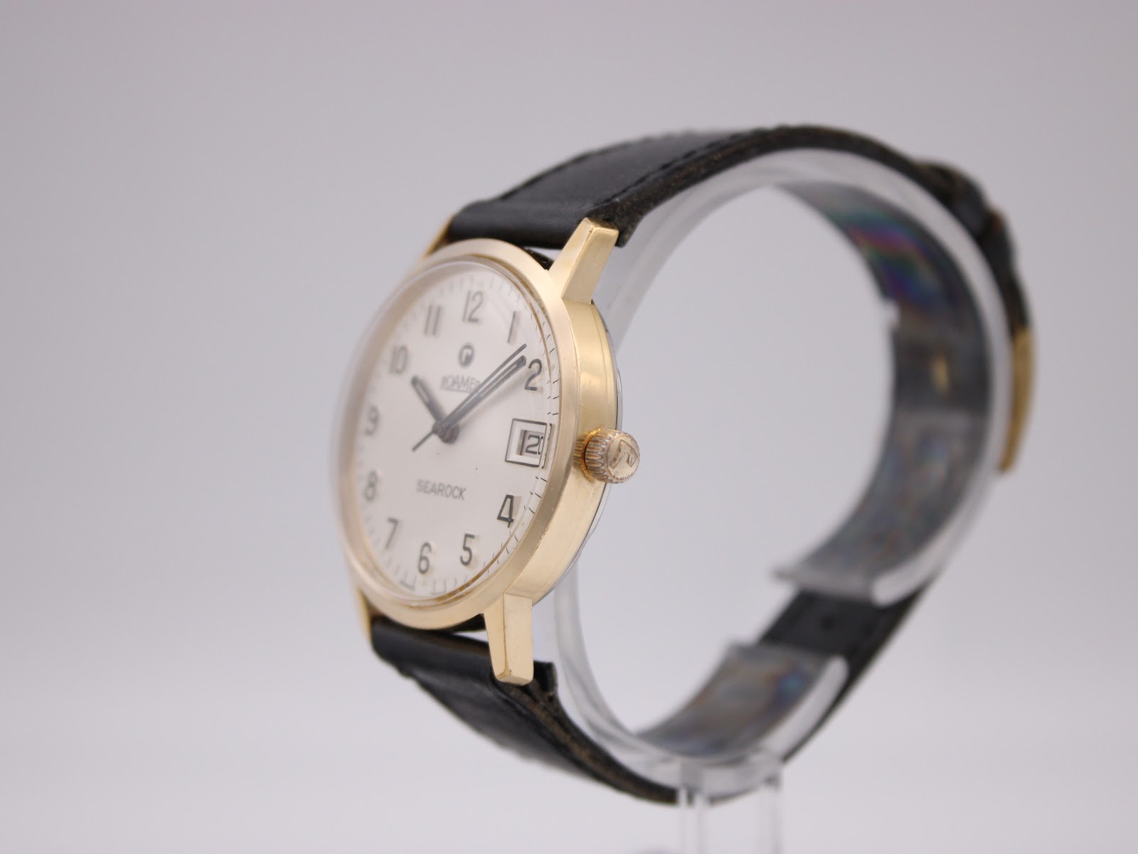 Right-side angled view of the Roamer Searock watch, showing the gold tone case and crown on a display stand.