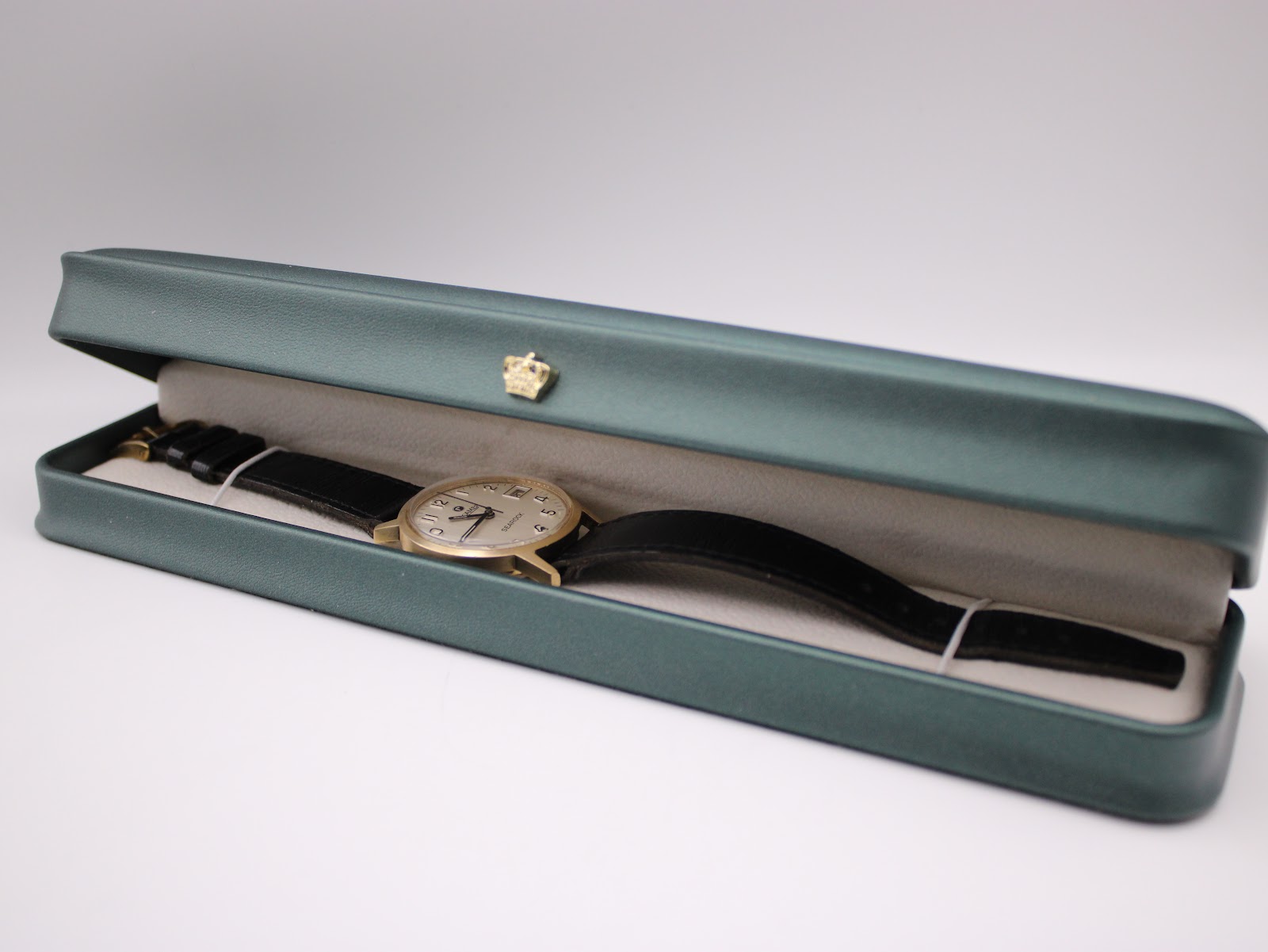 The Roamer Searock watch displayed inside an open green presentation box with a cream interior.