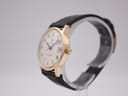 Right-side angled view of the Roamer Searock watch, showing the gold tone case and crown on a display stand.