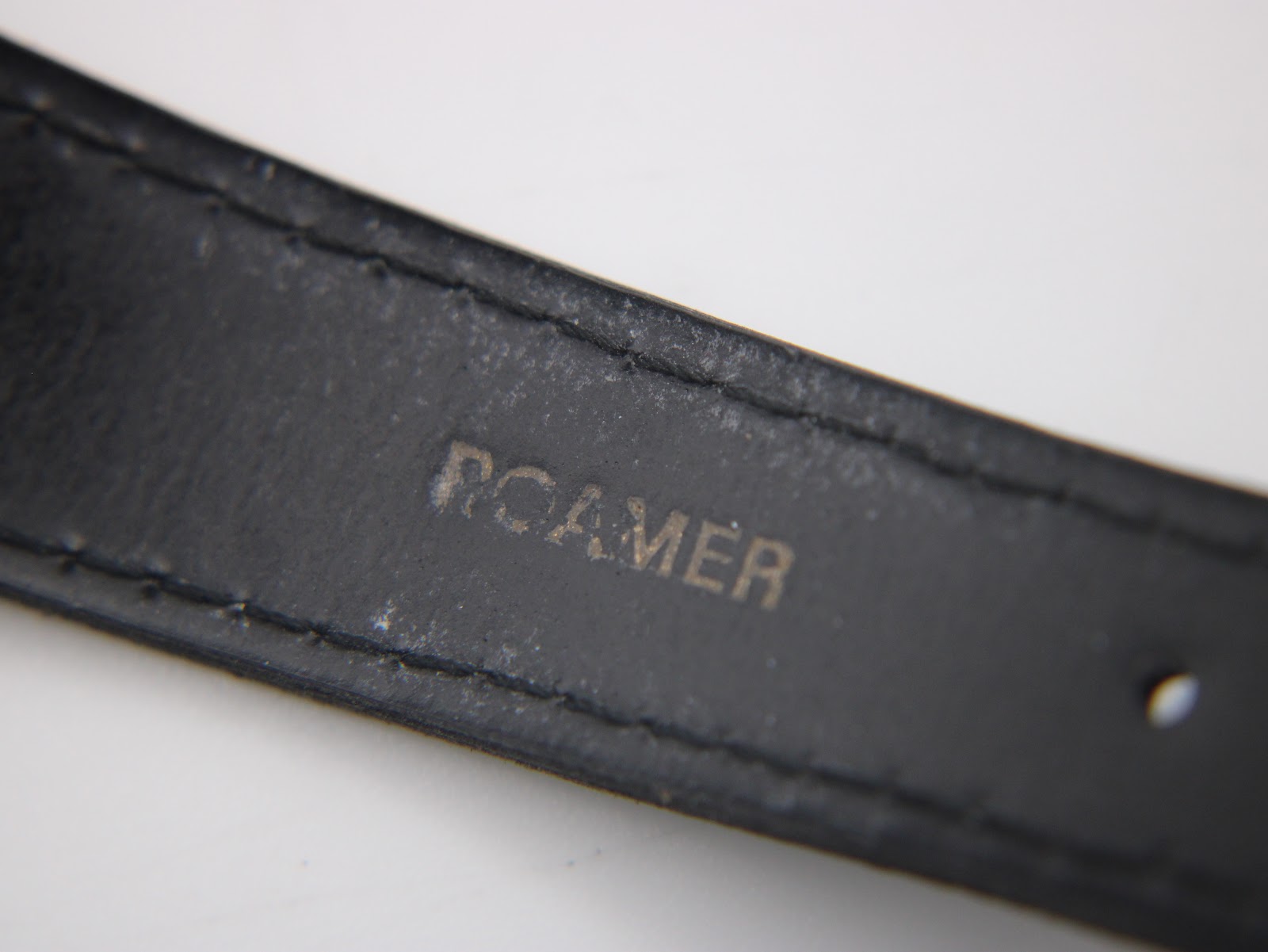 Underside of the black leather strap showing 'ROAMER' branding.