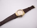 Overhead view of the Certina 288 watch laid flat, showing the full brown leather strap and gold-tone buckle.