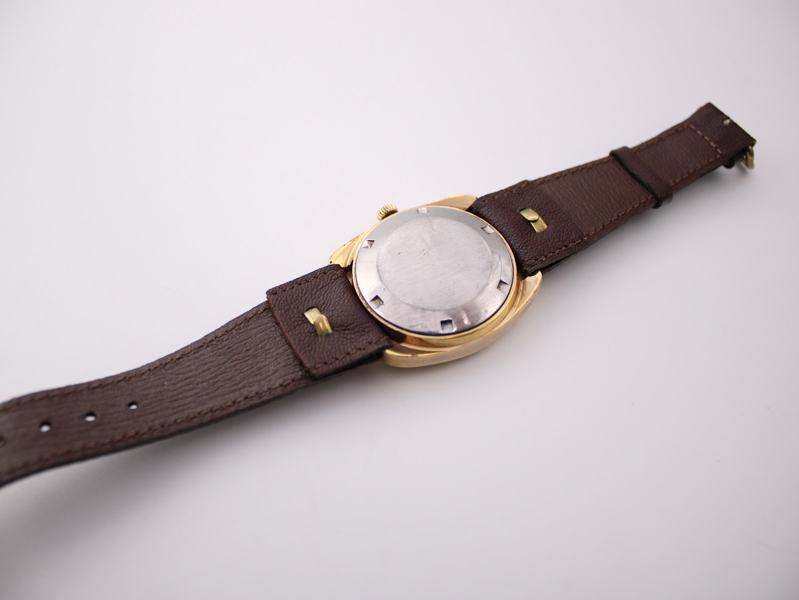Back view of the Certina 288 watch, showing the stainless steel case back and the full brown leather strap.