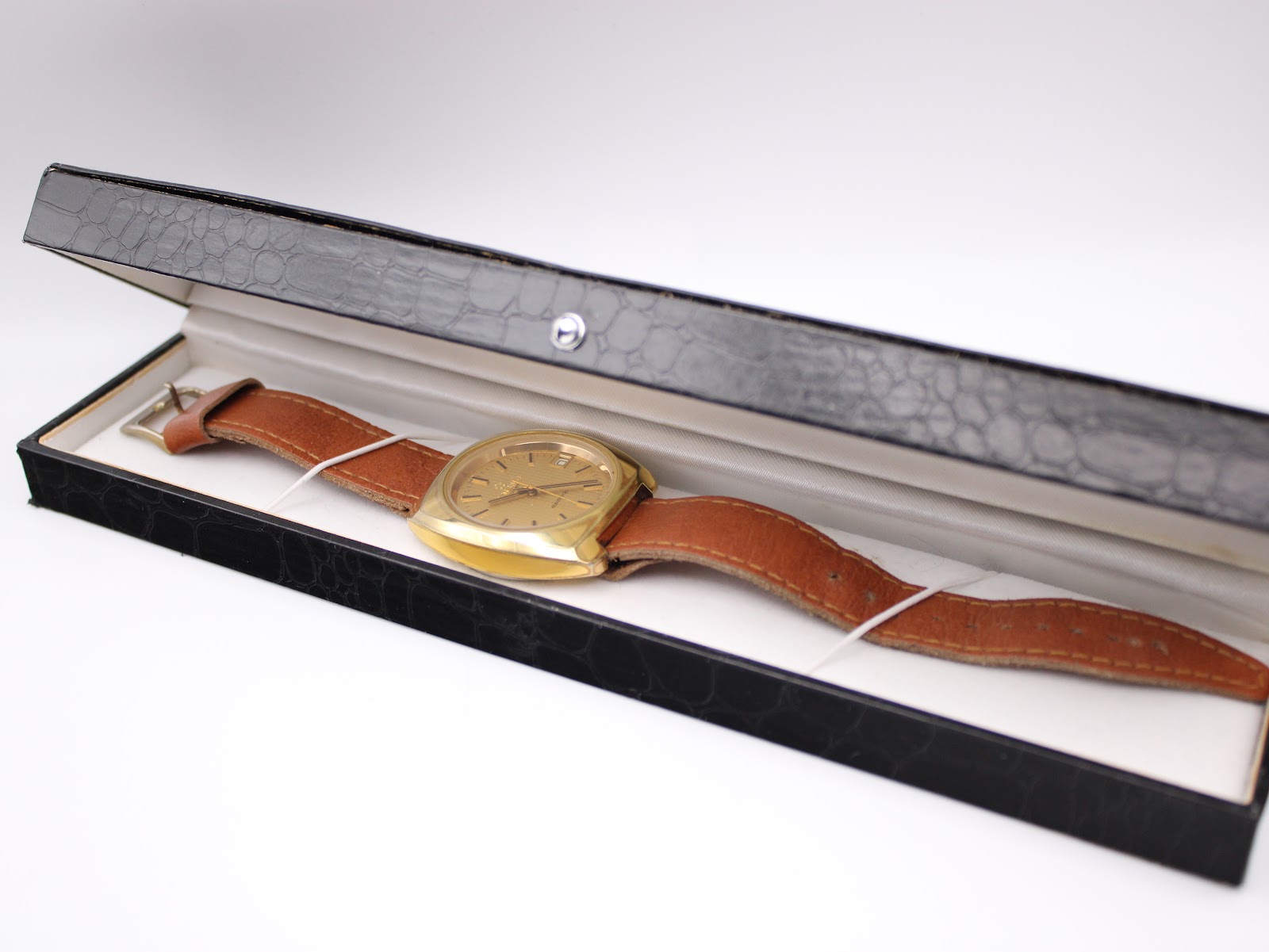 Eterna watch displayed inside a simple black presentation box with a faux crocodile texture.