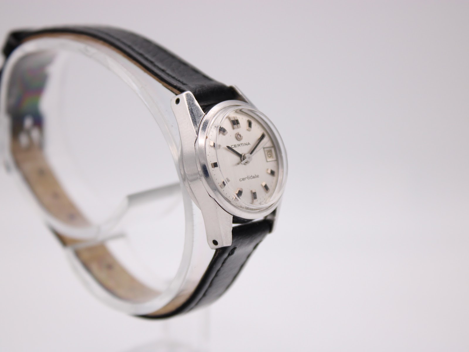 Left side profile view of the Certina Certidate watch on a display stand, highlighting the case shape and black leather strap.
