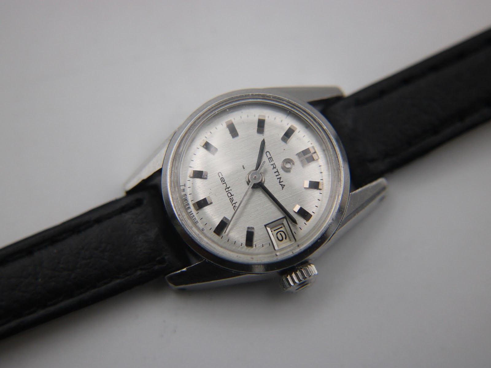 Angled view of the Certina Certidate dial and case, with the black leather strap visible, showcasing the 'Swiss Made' text.