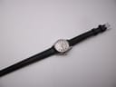 Overhead view of the Certina Certidate watch on its full black leather strap with silver buckle, against a white background.