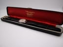 Watch inside a generic black Bravingtons watch box with red satin lining, angled view.